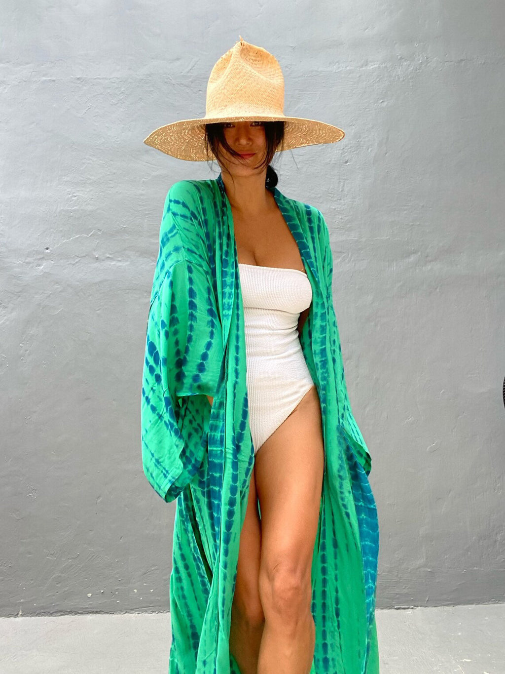 Trenches of Mariana rayon tie-dye beach cover-up with sun protection, loose fit, worn over bikini for women’s vacation swimwear.