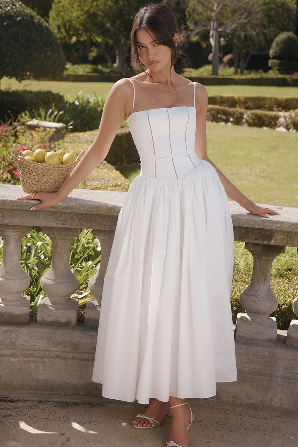 Trenches of Mariana long sleeveless spring dress with spaghetti straps, printed flared skirt, low neckline, and waist-cinching fit.