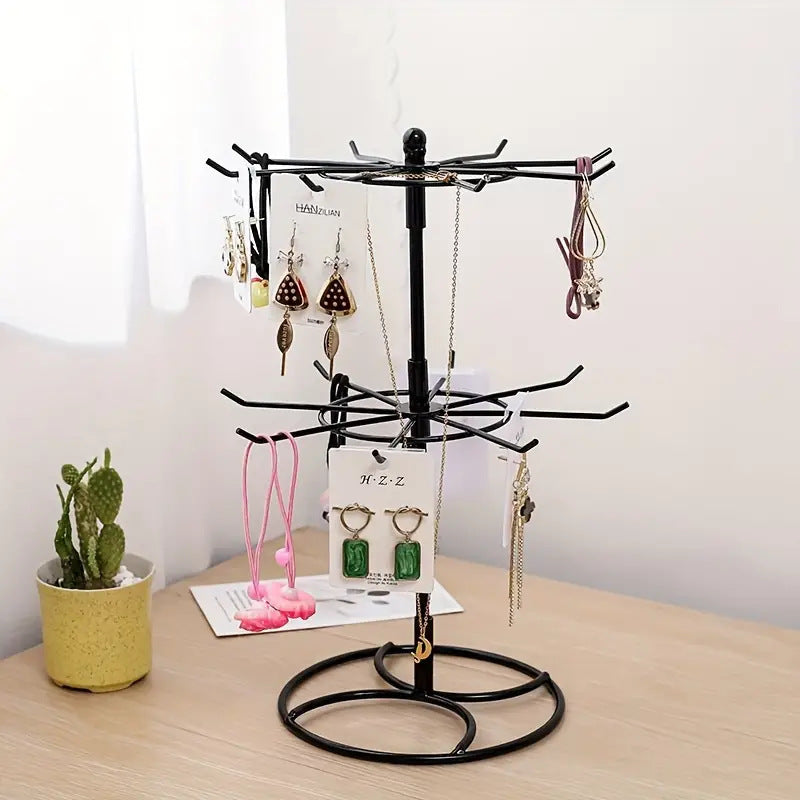 Trenches of Mariana rotating jewelry display rack with two-layer shelf for necklaces and bracelets, shown with jewelry hanging.