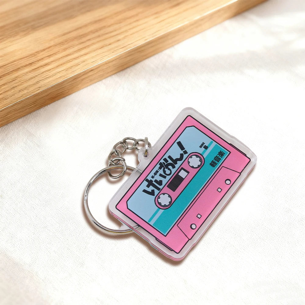Pink K-On! cassette tape acrylic keychain featuring the virtual band HTT, Japanese anime-themed pendant by Trenches of Mariana