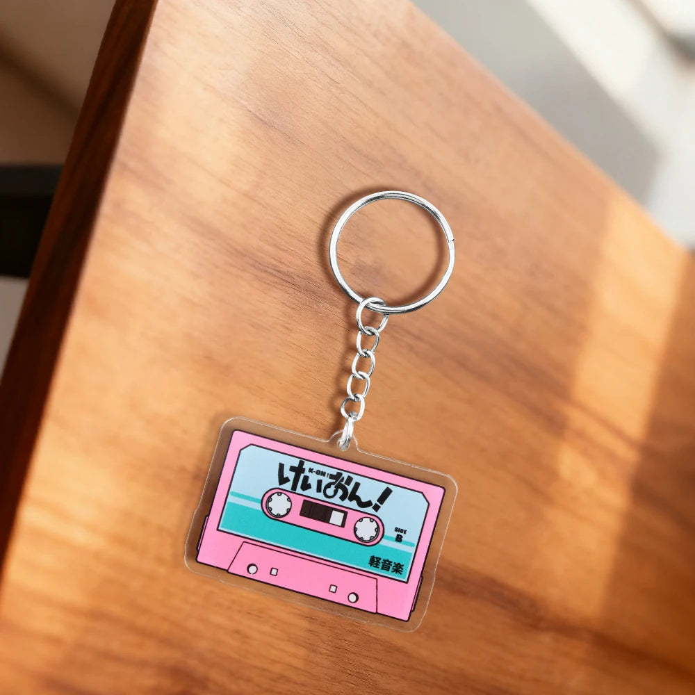 Pink K-On! cassette tape acrylic keychain featuring HTT band logo, anime-themed design, and colorful pendant from Trenches of Mariana