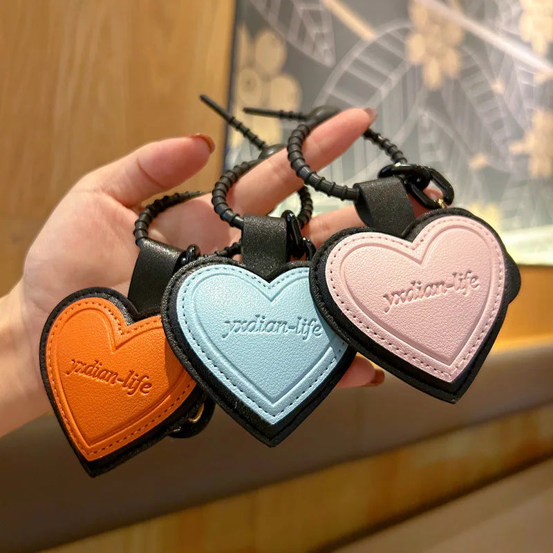 Pink leather heart-shaped car keychain with personalized face design, ideal as a bag pendant for men and women by Trenches of Mariana.