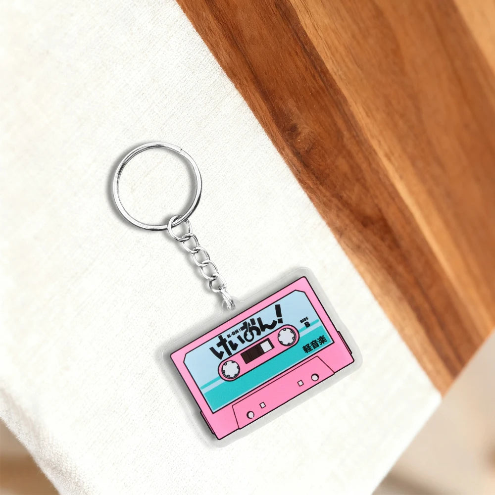 Pink K-On! cassette tape acrylic keychain featuring HTT band logo, Japanese anime-style design, and a fun pendant accessory.